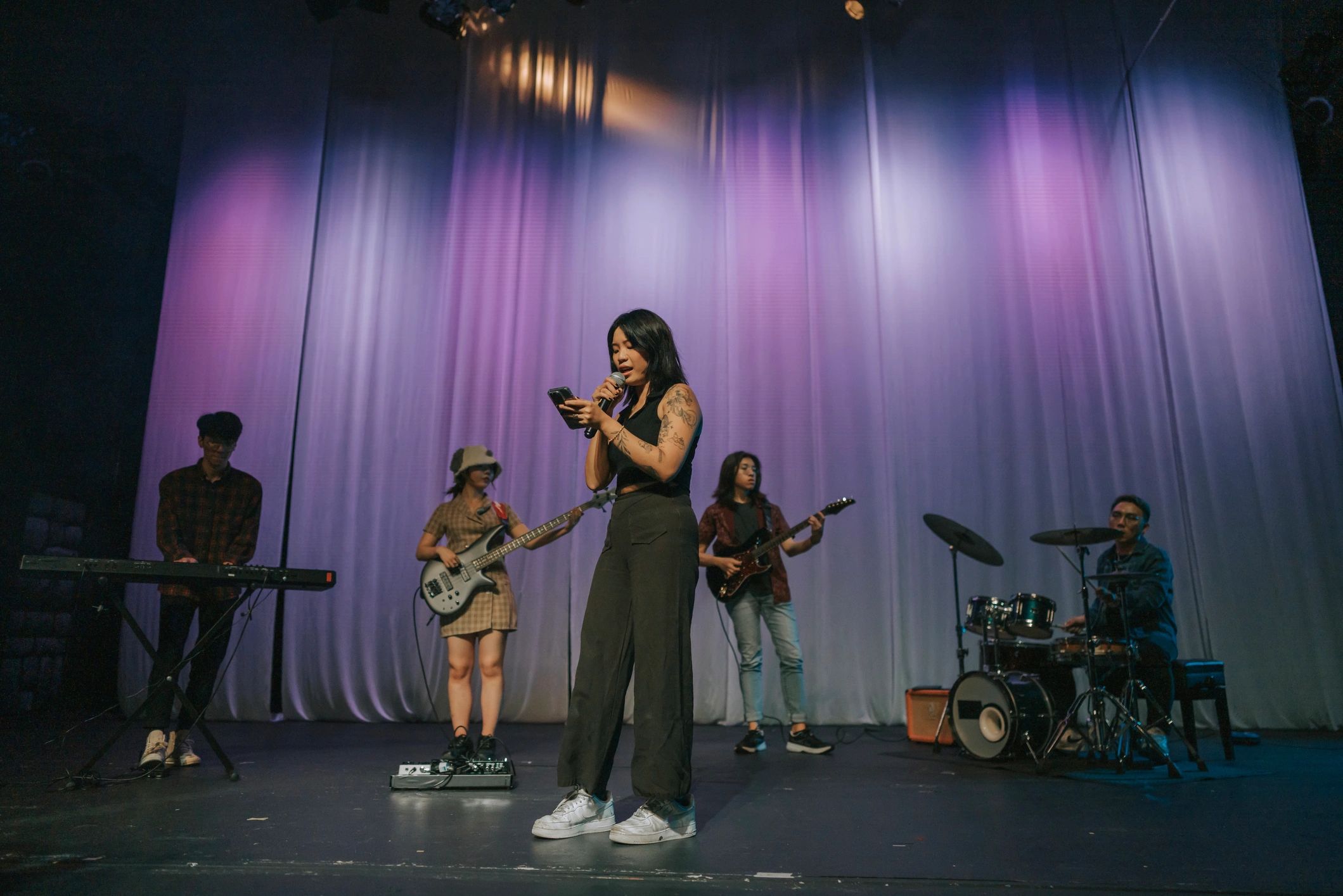 Lead singer performing with band on stage