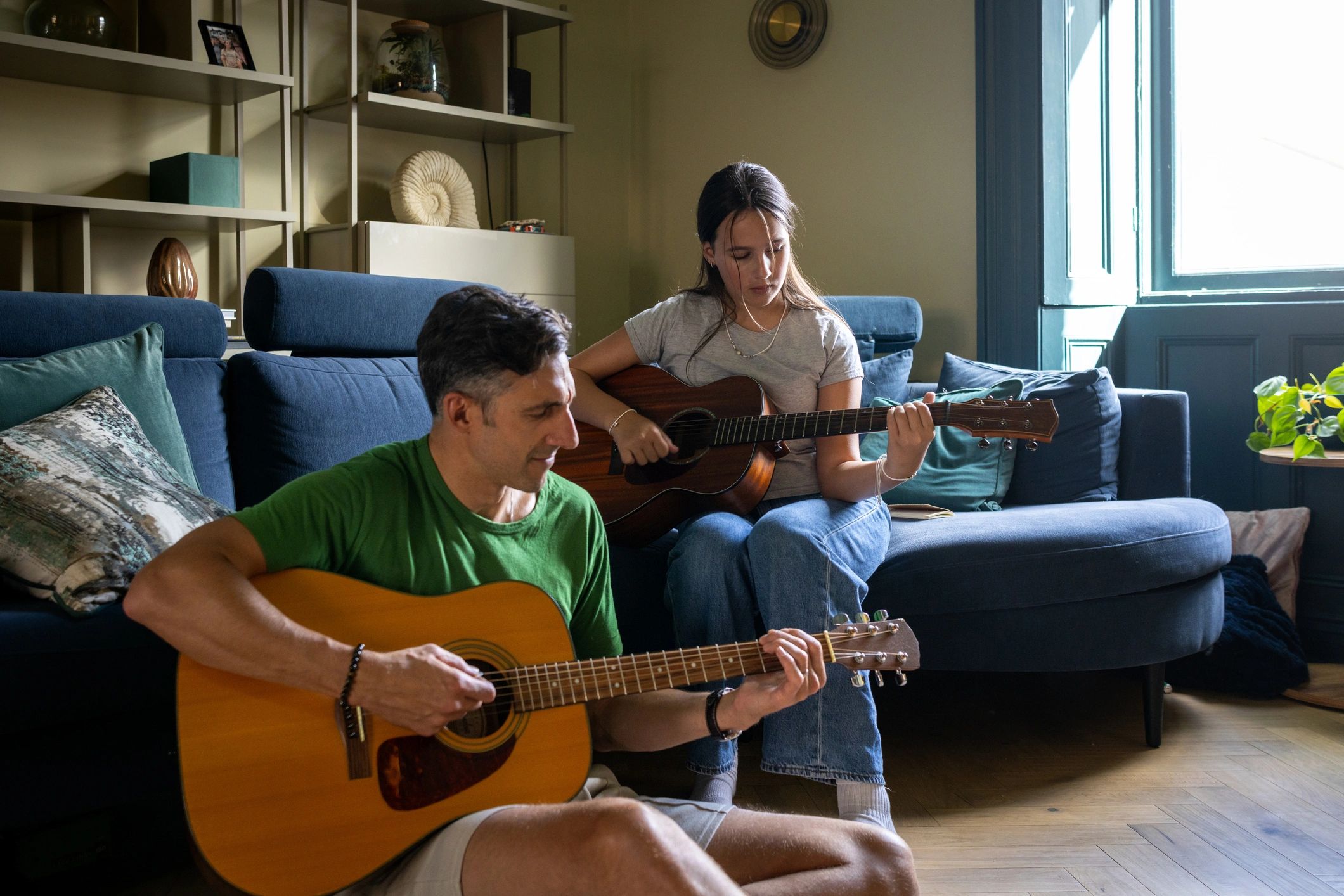 Smiling person holding an acoustic guitar